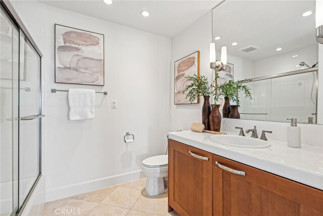 bathroom with visible vents, toilet, a shower with door, tile patterned floors, and vanity