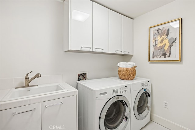 laundry area featuring cabinet space, a sink, baseboards, and separate washer and dryer