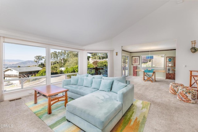 living room with vaulted ceiling, a mountain view, light colored carpet, and crown molding