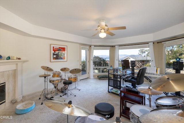 living room with ceiling fan and a fireplace