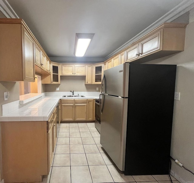 kitchen featuring light brown cabinetry, dishwasher, sink, stainless steel fridge, and light tile patterned floors