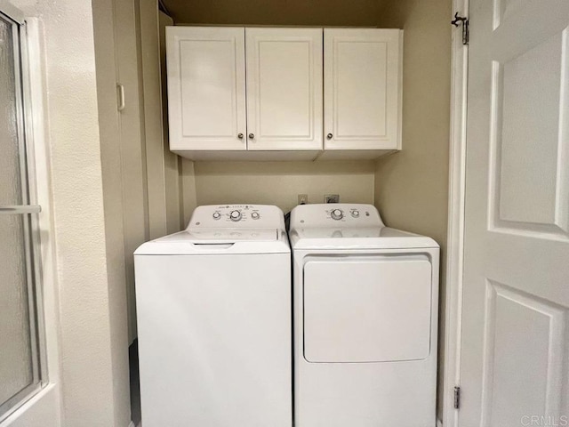 washroom with cabinets and washer and clothes dryer