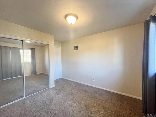 unfurnished bedroom featuring carpet flooring and a closet