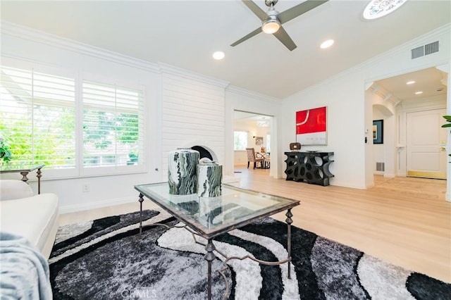 living room featuring crown molding, wood-type flooring, and ceiling fan