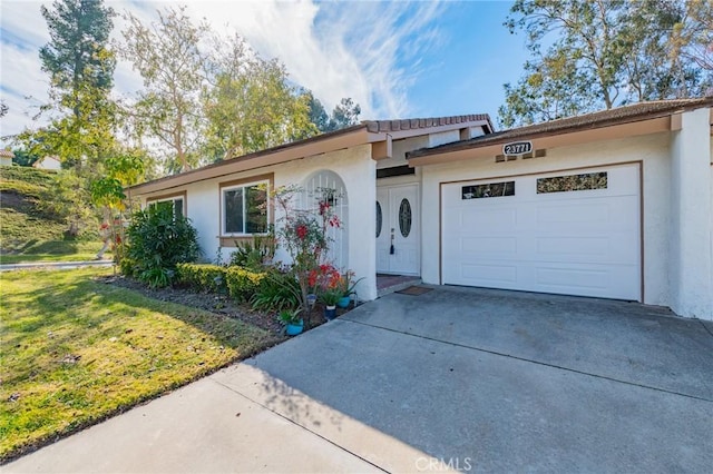 single story home featuring a garage and a front lawn