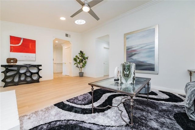 living room featuring hardwood / wood-style flooring, ceiling fan, and ornamental molding