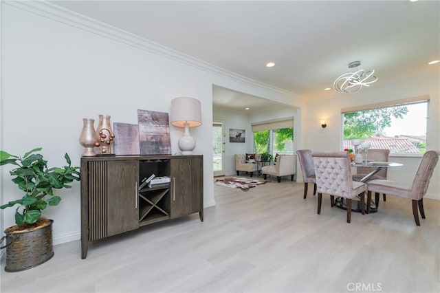 dining room with ornamental molding and light wood-type flooring