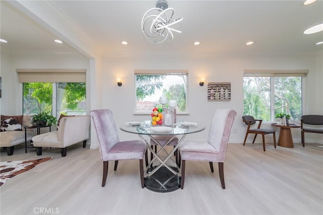 dining space with crown molding, a chandelier, and light wood-type flooring