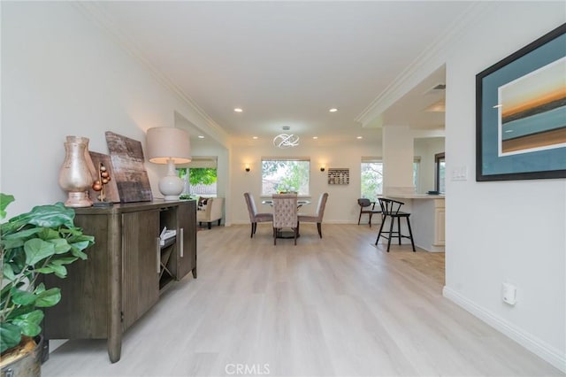 dining space featuring crown molding and light hardwood / wood-style flooring