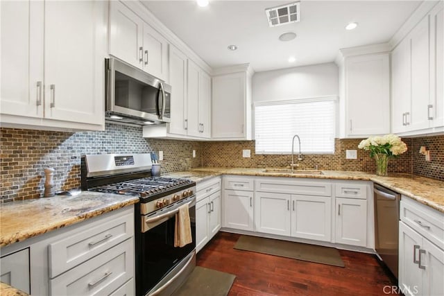 kitchen featuring dark hardwood / wood-style flooring, sink, stainless steel appliances, and white cabinets