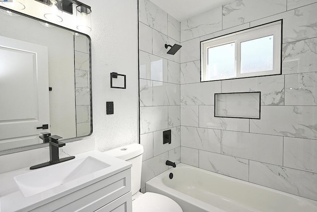 full bathroom with tiled shower / bath, vanity, and toilet