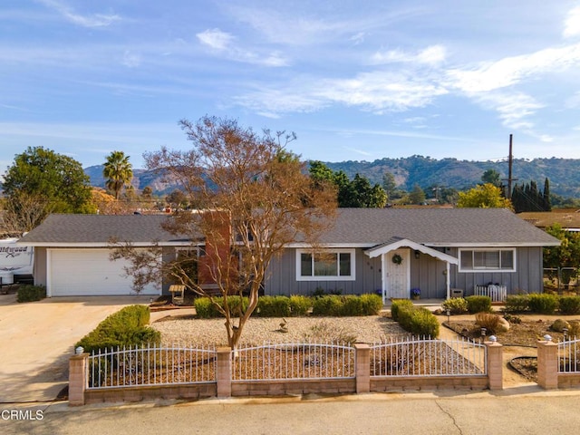 ranch-style house featuring a garage and a mountain view