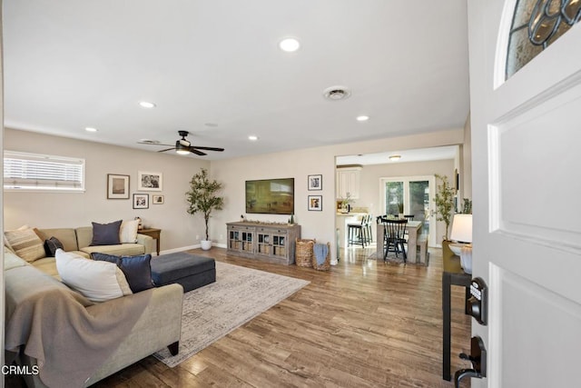 living room with wood-type flooring and ceiling fan