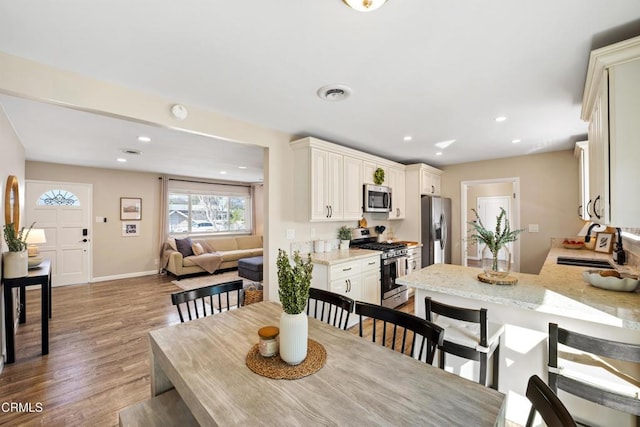 dining room featuring sink and light hardwood / wood-style floors