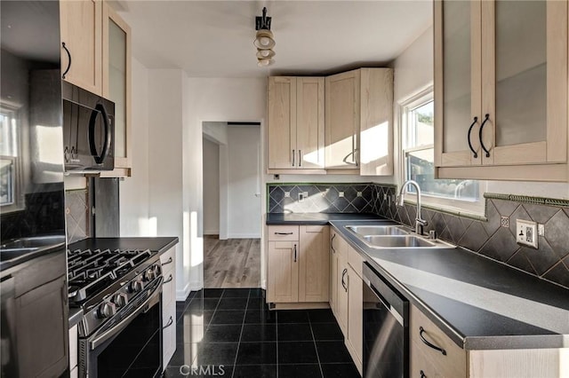 kitchen with sink, gas stove, light brown cabinets, dishwasher, and backsplash