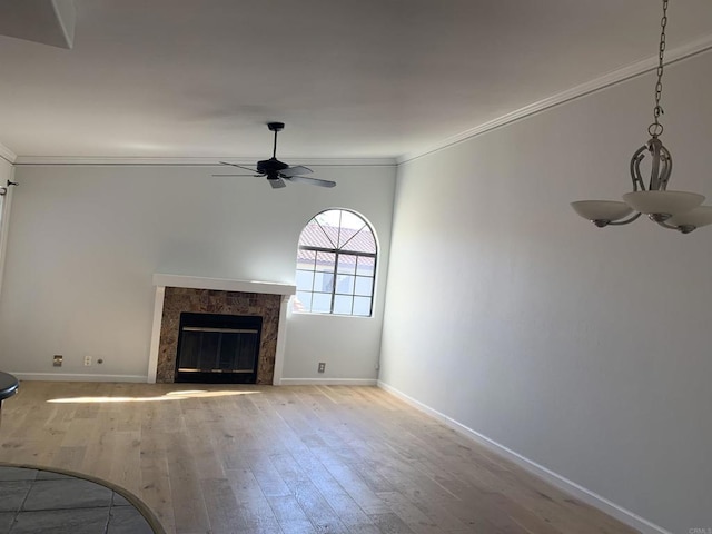 unfurnished living room with crown molding, a high end fireplace, light hardwood / wood-style floors, and ceiling fan