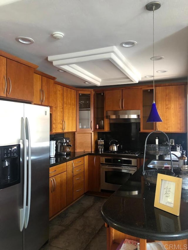 kitchen with stainless steel appliances, decorative light fixtures, sink, and backsplash