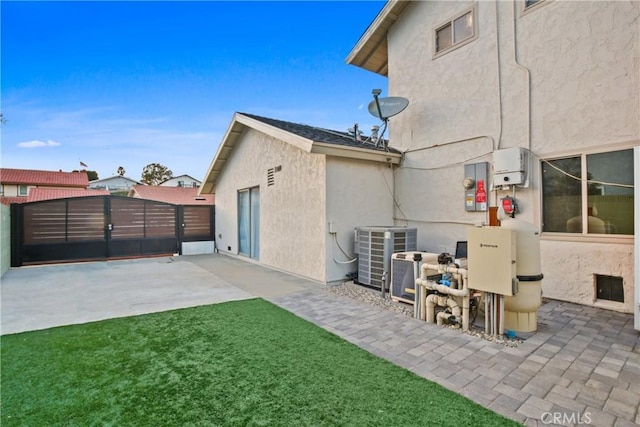 back of house with a patio, central AC, and a lawn