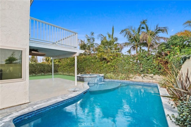 view of swimming pool with an in ground hot tub