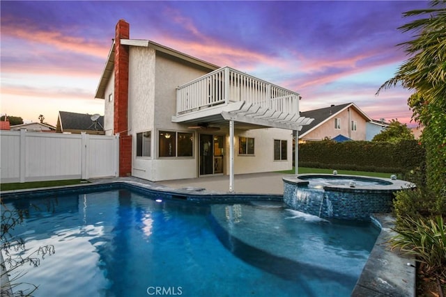 exterior space featuring a pool with hot tub, a pergola, pool water feature, and a balcony