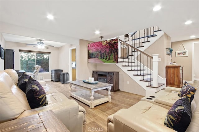 living room featuring ceiling fan and light hardwood / wood-style flooring