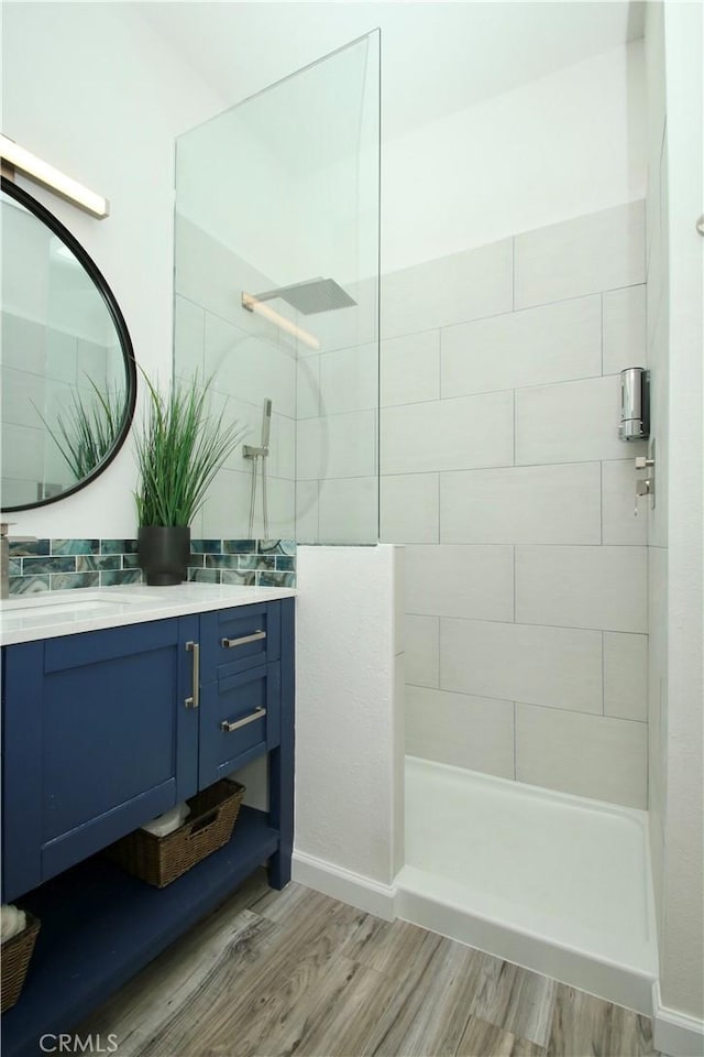 bathroom with vanity, hardwood / wood-style floors, and tiled shower