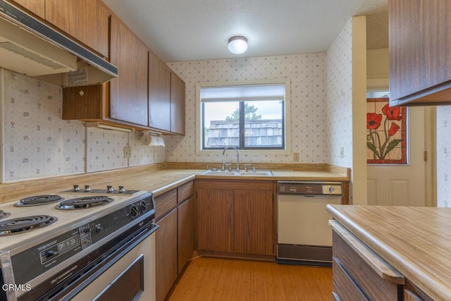 kitchen with white appliances, sink, and light wood-type flooring