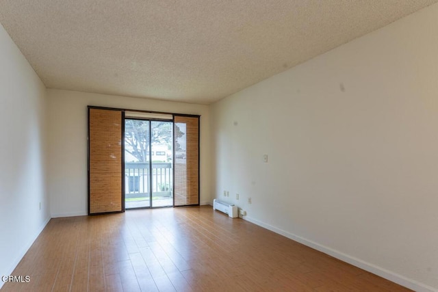 empty room with wood-type flooring and a textured ceiling