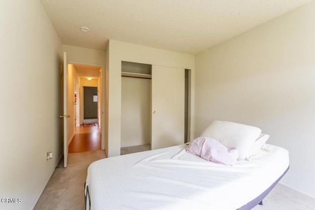 bedroom featuring light carpet and a closet