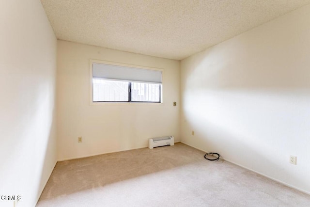 carpeted empty room with baseboard heating and a textured ceiling