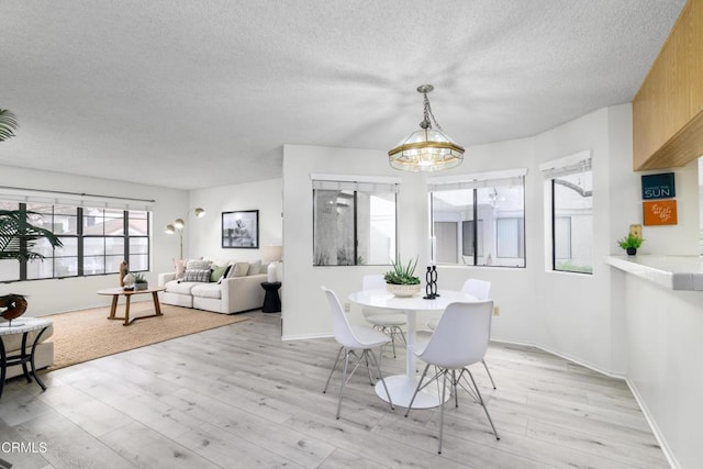 dining space featuring light hardwood / wood-style floors and a textured ceiling