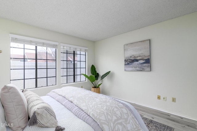 bedroom featuring hardwood / wood-style floors and a textured ceiling