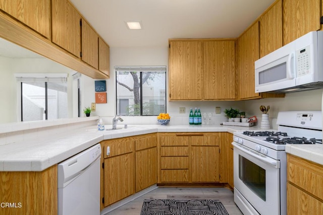 kitchen with sink, white appliances, and kitchen peninsula