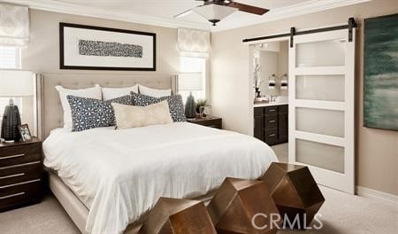 bedroom featuring crown molding, ensuite bath, light colored carpet, and a barn door