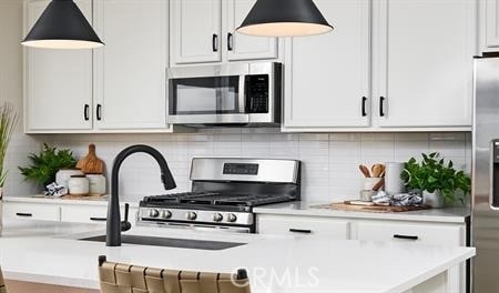 kitchen featuring stainless steel appliances, white cabinetry, and decorative backsplash