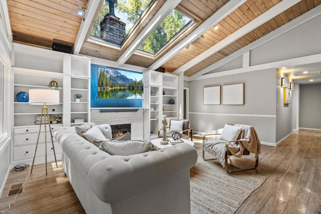 living room with wood-type flooring, a skylight, wooden ceiling, beamed ceiling, and a fireplace