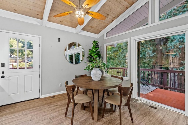 dining space featuring vaulted ceiling with beams, plenty of natural light, and light hardwood / wood-style floors