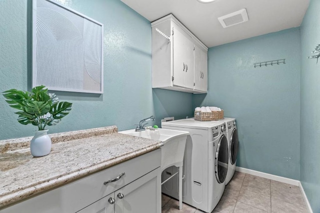 laundry room with cabinets, light tile patterned flooring, and independent washer and dryer