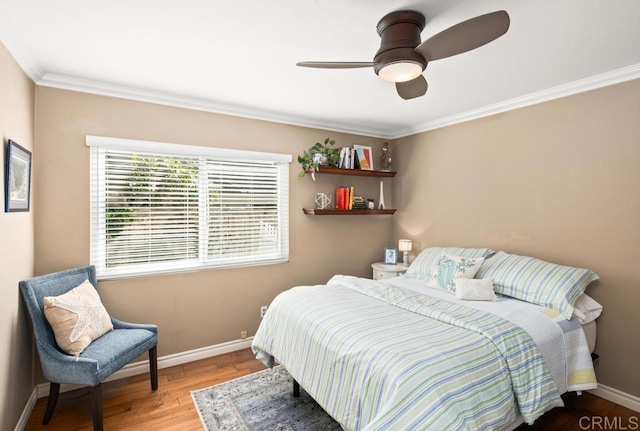 bedroom with hardwood / wood-style flooring, crown molding, and ceiling fan