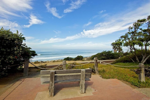 view of community with a water view, a view of the beach, and a patio