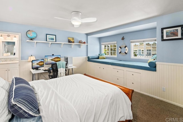 bedroom with wooden walls, ceiling fan, connected bathroom, and carpet flooring