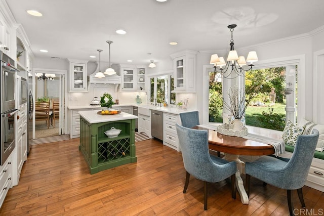 kitchen with green cabinets, white cabinetry, hanging light fixtures, an inviting chandelier, and a kitchen island