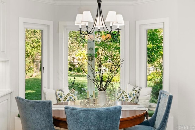 dining room with crown molding, plenty of natural light, and a notable chandelier