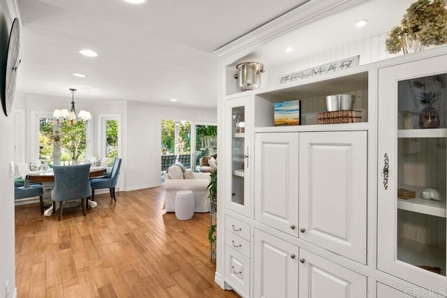 interior space featuring an inviting chandelier and light hardwood / wood-style flooring