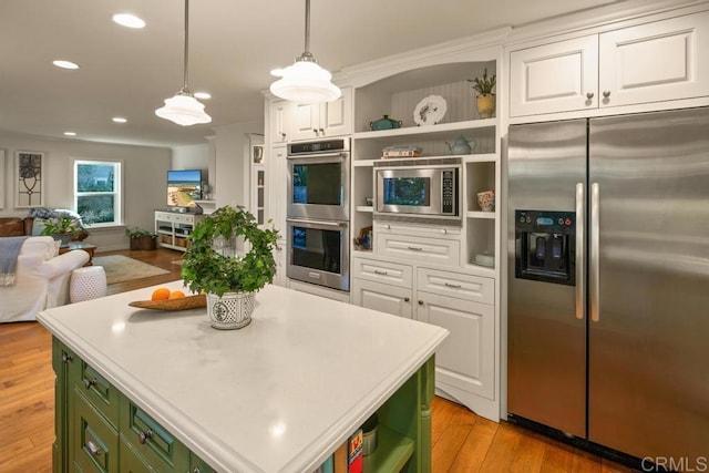 kitchen featuring hanging light fixtures, white cabinetry, appliances with stainless steel finishes, and green cabinets