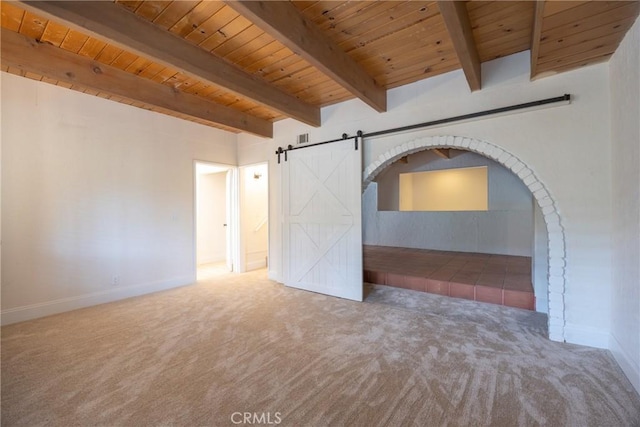 spare room featuring wood ceiling, a barn door, carpet, and beam ceiling