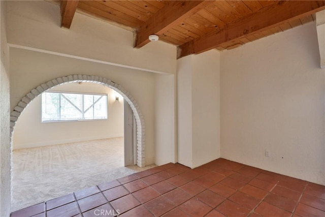 carpeted empty room with beam ceiling and wooden ceiling