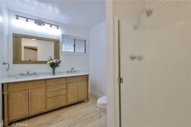 bathroom featuring hardwood / wood-style flooring, vanity, toilet, and a shower with shower door