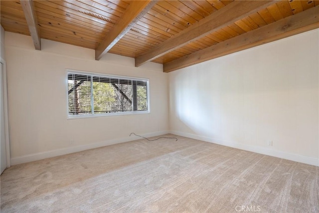 carpeted spare room with beam ceiling and wooden ceiling