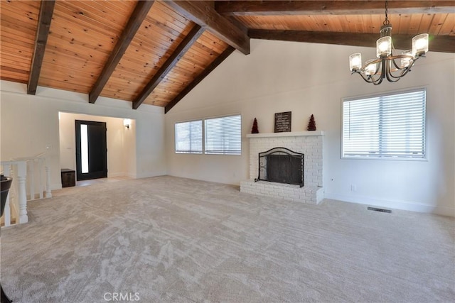 unfurnished living room with beamed ceiling, a wealth of natural light, wood ceiling, and a fireplace